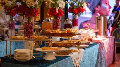 Delicious food catering services spread with pastries and floral centerpieces.