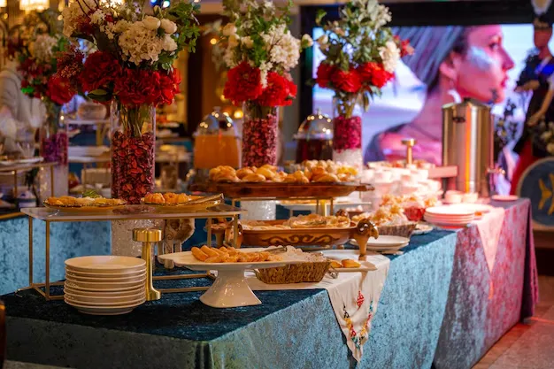 Delicious food catering services spread with pastries and floral centerpieces.